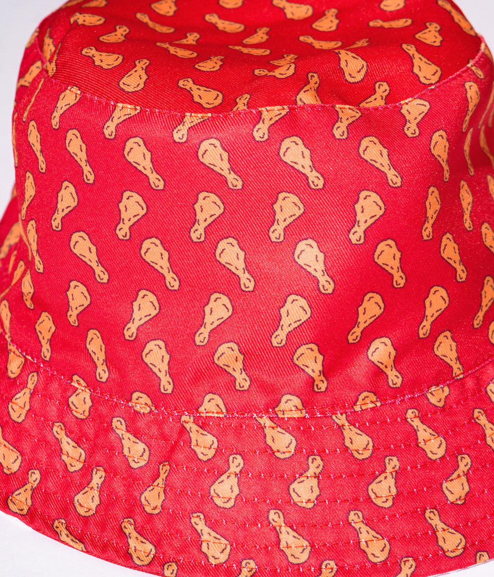 close up of KFC bucket hat with chicken drumstick pattern on red